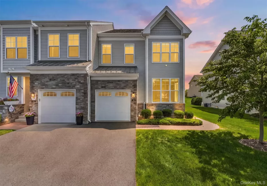 Contemporary townhome exterior featuring light gray siding and stone accents Contemporary townhome exterior featuring light gray siding and stone accents