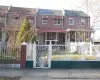 Traditional-style house with a gate, brick siding, and a fenced front yard Traditional-style house with a gate, brick siding, and a fenced front yard