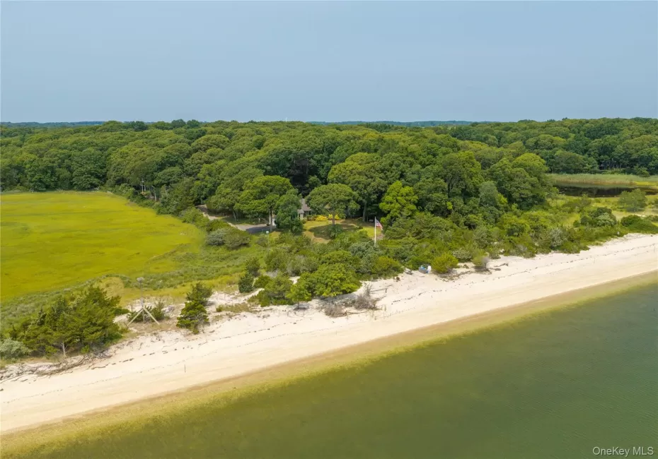 Expansive waterfront property featuring a sandy beach, mature tree line, and tranquil bay Expansive waterfront property featuring a sandy beach, mature tree line, and tranquil bay