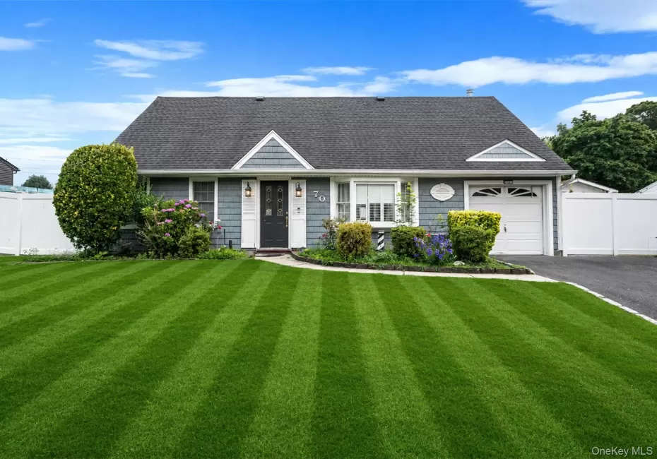 Cape Cod residence featuring blue siding, white trim, a dark asphalt shingle roof, a single garage, and a paved driveway Cape Cod residence featuring blue siding, white trim, a dark asphalt shingle roof, a single garage, and a paved driveway