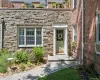 Stone facade entry with a light green paneled door, flanked by a white trim surround Stone facade entry with a light green paneled door, flanked by a white trim surround