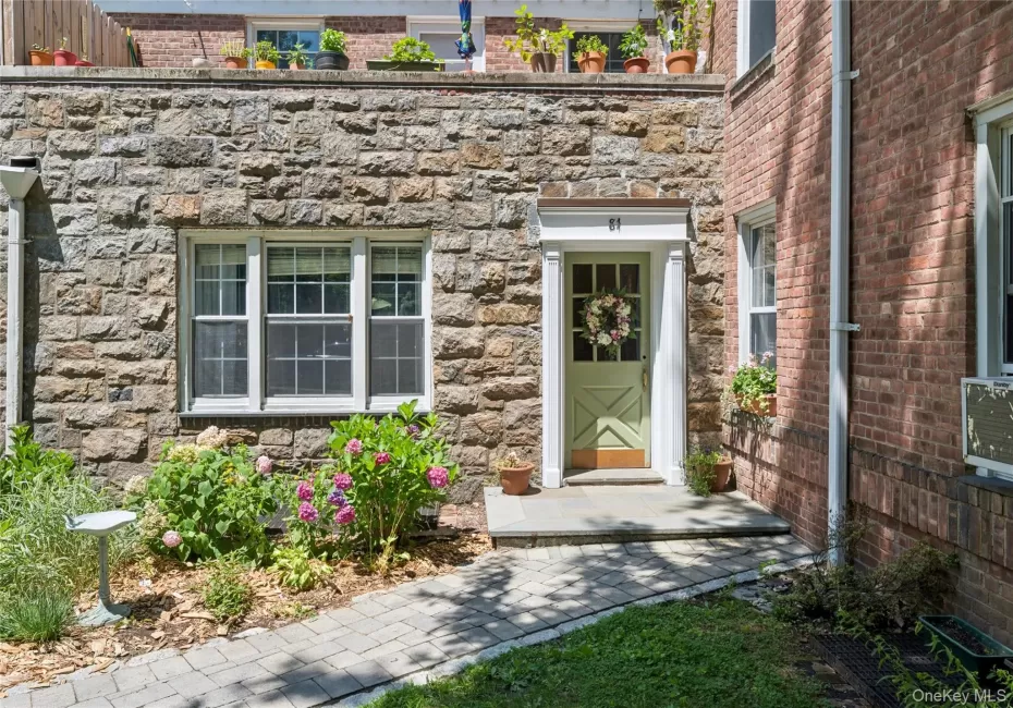 Stone facade entry with a light green paneled door, flanked by a white trim surround Stone facade entry with a light green paneled door, flanked by a white trim surround