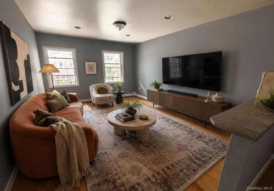 Living area featuring wood-finish flooring, recessed lighting, and two double-hung windows Living area featuring wood-finish flooring, recessed lighting, and two double-hung windows
