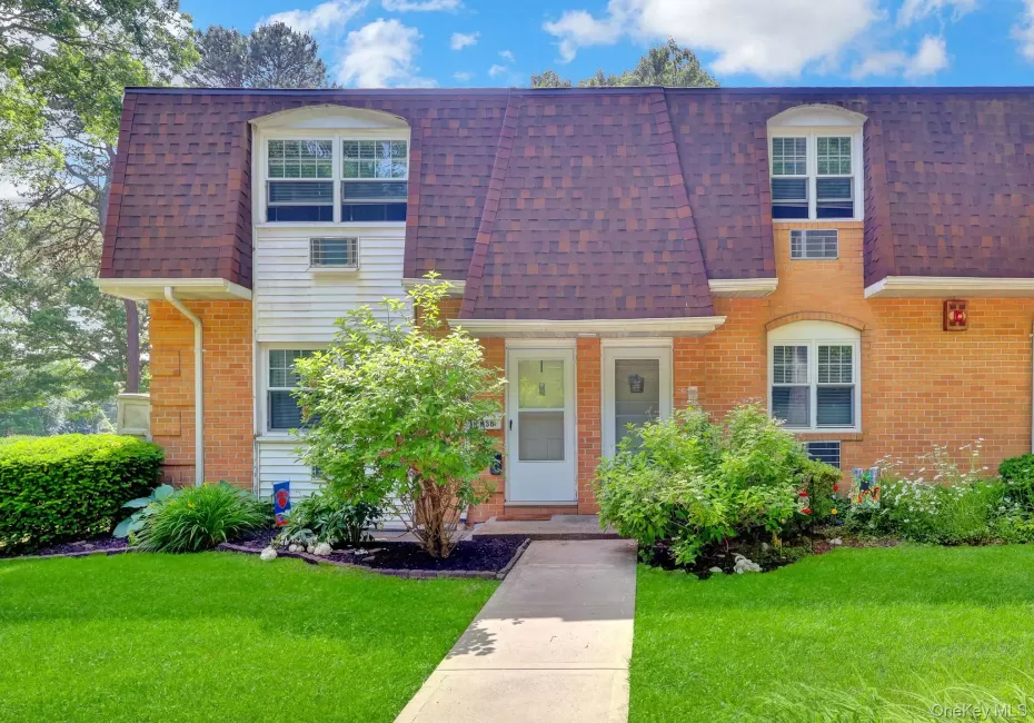 Brick and white siding exterior with a gambrel roofline Brick and white siding exterior with a gambrel roofline