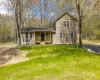 Two-story residence featuring light brown horizontal siding, a dark asphalt shingle roof, and multiple windows with white trim Two-story residence featuring light brown horizontal siding, a dark asphalt shingle roof, and multiple windows with white trim