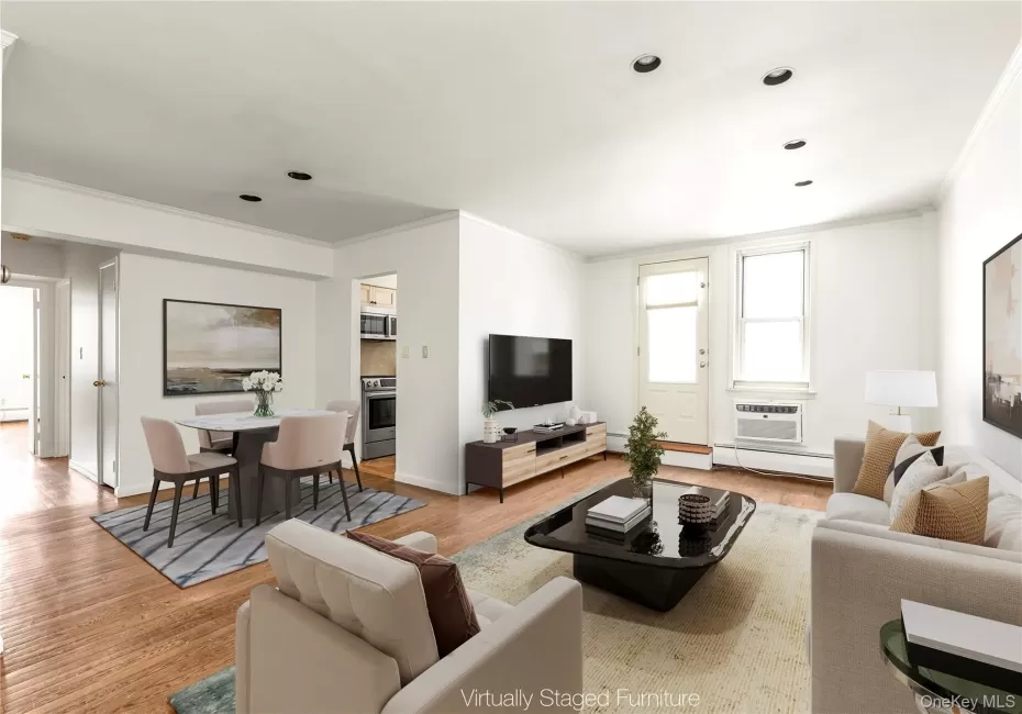 Spacious living and dining area featuring hardwood flooring, recessed lighting, and crown molding. Spacious living and dining area featuring hardwood flooring, recessed lighting, and crown molding.