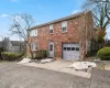 Colonial home featuring brick siding, a garage, and concrete driveway Colonial home featuring brick siding, a garage, and concrete driveway