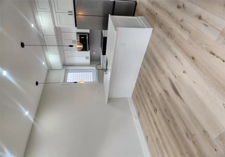 Modern kitchen featuring white shaker cabinetry, stainless steel appliances, and a central island with a sink Modern kitchen featuring white shaker cabinetry, stainless steel appliances, and a central island with a sink