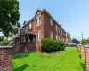 View of property exterior featuring brick siding and a yard View of property exterior featuring brick siding and a yard