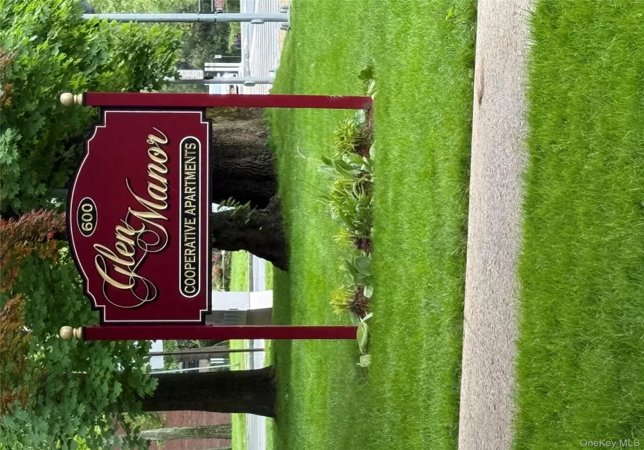 Community sign featuring a yard Community sign featuring a yard