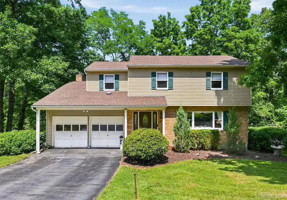 Split-level home featuring a two-car garage with overhead doors Split-level home featuring a two-car garage with overhead doors