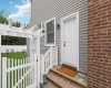 Exterior features include gray horizontal siding, a paneled entry door with a black fixture, and a red brick facade Exterior features include gray horizontal siding, a paneled entry door with a black fixture, and a red brick facade