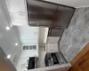Modern kitchen featuring white shaker cabinetry, stainless steel appliances, light-toned countertops, a subway tile backsplash, and wood-finish flooring Modern kitchen featuring white shaker cabinetry, stainless steel appliances, light-toned countertops, a subway tile backsplash, and wood-finish flooring