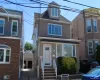 Three-story residence featuring light gray siding and a dormer window Three-story residence featuring light gray siding and a dormer window