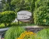 "Kemeys Cove" signage set within lush landscaping, featuring a stone retaining wall and vibrant yellow flowering plants "Kemeys Cove" signage set within lush landscaping, featuring a stone retaining wall and vibrant yellow flowering plants