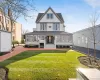 Victorian home featuring a shingled roof and a front yard Victorian home featuring a shingled roof and a front yard