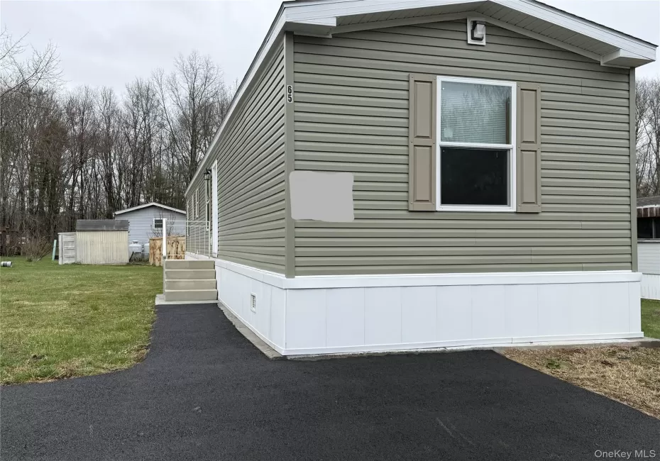 View of side of home featuring an outbuilding and a yard View of side of home featuring an outbuilding and a yard