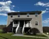 View of front of home featuring covered porch, a front yard, and stairs View of front of home featuring covered porch, a front yard, and stairs