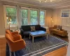 Living room with wood finished floors, healthy amount of natural light, a chandelier, and ornamental molding Living room with wood finished floors, healthy amount of natural light, a chandelier, and ornamental molding