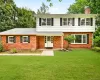 Traditional two-story residence featuring a red brick and white siding exterior Traditional two-story residence featuring a red brick and white siding exterior