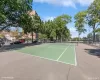 Outdoor tennis court with green playing surface and white line markings Outdoor tennis court with green playing surface and white line markings