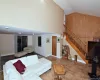 Living room with baseboards, stairway, and high vaulted ceiling Living room with baseboards, stairway, and high vaulted ceiling