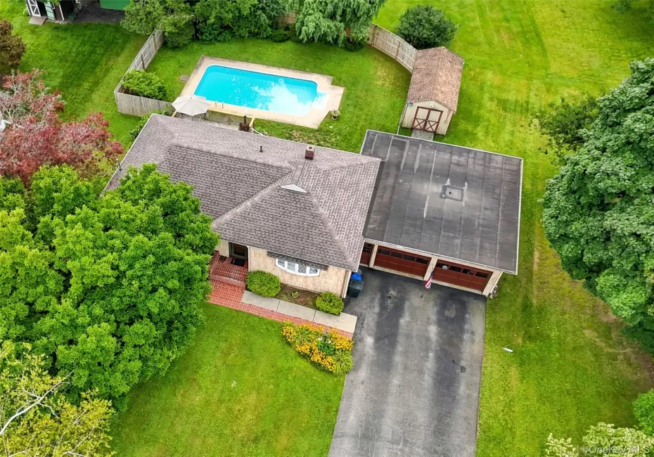 Property featuring a shingle roof, attached two-car garage, and a paved driveway Property featuring a shingle roof, attached two-car garage, and a paved driveway