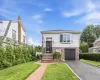 Contemporary residence featuring a brick walkway, manicured lawn, and an attached garage Contemporary residence featuring a brick walkway, manicured lawn, and an attached garage