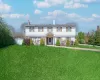 Colonial inspired home with a chimney, a front lawn, and fence Colonial inspired home with a chimney, a front lawn, and fence