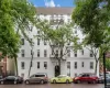 White multi-story building featuring numerous windows and an arched entryway White multi-story building featuring numerous windows and an arched entryway