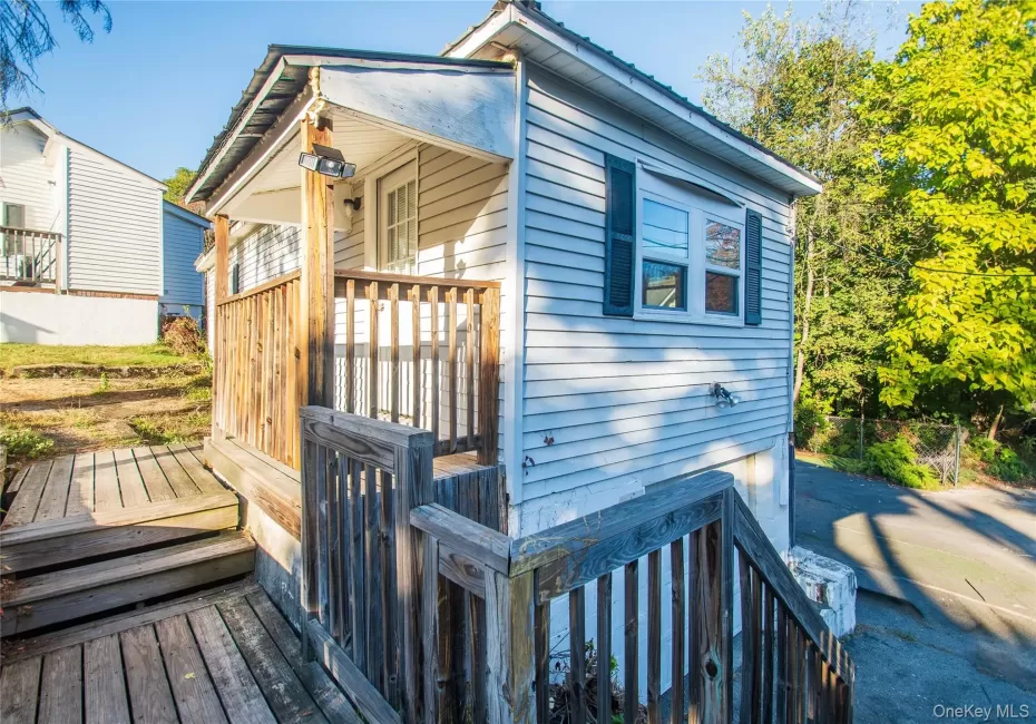 View of front facade with a deck, stairs, main entry from driveway. View of front facade with a deck, stairs, main entry from driveway.