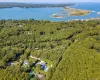 Aerial view of property and surrounding area featuring a heavily wooded area and property parcel outlined Aerial view of property and surrounding area featuring a heavily wooded area and property parcel outlined