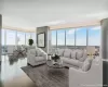 Living room with a wealth of natural light, wood-type flooring, and a wall of windows Living room with a wealth of natural light, wood-type flooring, and a wall of windows