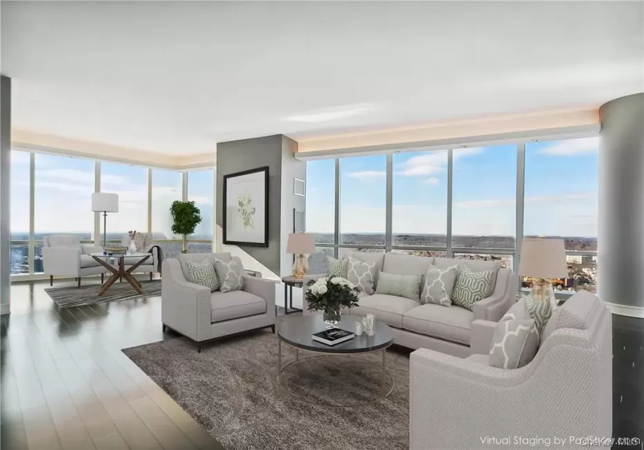 Living room with a wealth of natural light, wood-type flooring, and a wall of windows Living room with a wealth of natural light, wood-type flooring, and a wall of windows