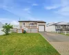 Welcoming front elevation featuring a raised ranch design with composite decking, white railings, and an attached garage Welcoming front elevation featuring a raised ranch design with composite decking, white railings, and an attached garage