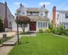 Classic Colonial-style home with a symmetrical facade, dual gables, and a welcoming red entry door Classic Colonial-style home with a symmetrical facade, dual gables, and a welcoming red entry door