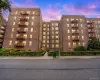 Brick multi-story building featuring multiple windows, exterior fire escapes, and ground-level landscaping Brick multi-story building featuring multiple windows, exterior fire escapes, and ground-level landscaping