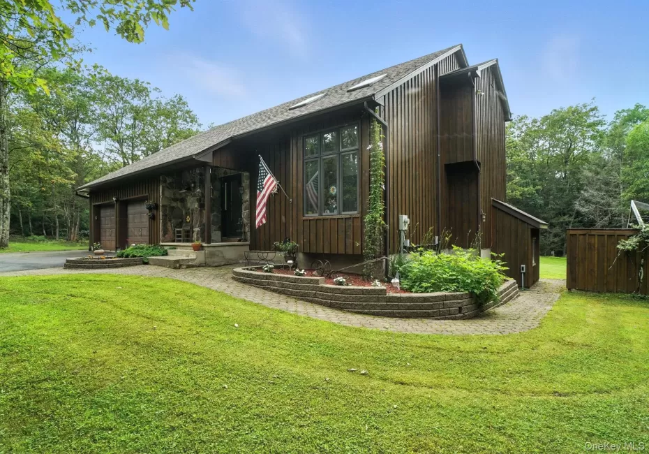 View of front of property featuring a garage, a front lawn, and driveway View of front of property featuring a garage, a front lawn, and driveway