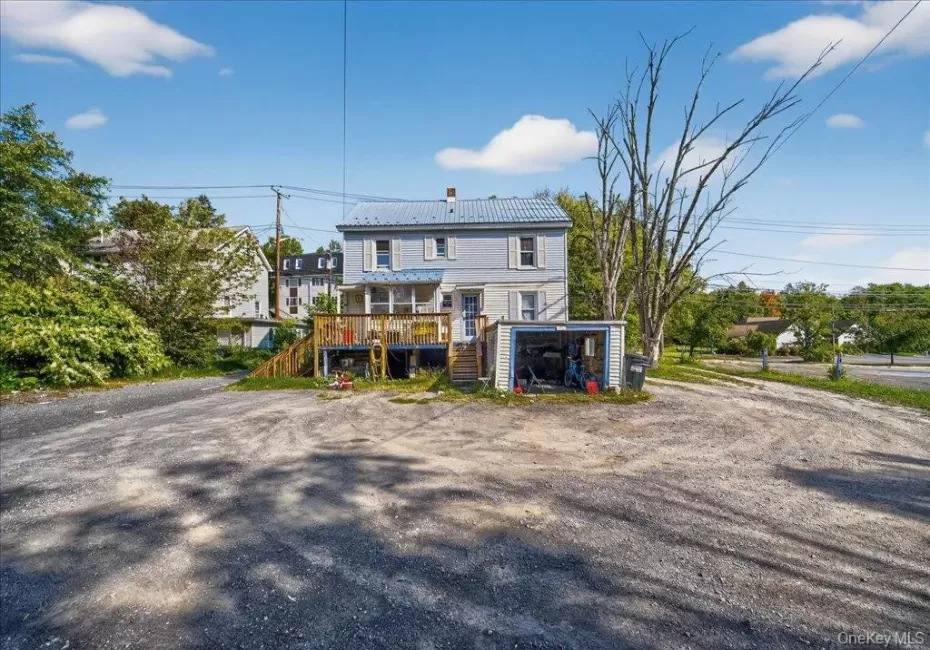 Rear view of property featuring stairway, a deck, a chimney, and a metal roof Rear view of property featuring stairway, a deck, a chimney, and a metal roof