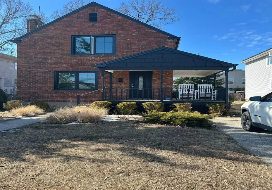View of front of property with a porch, brick siding, and a chimney View of front of property with a porch, brick siding, and a chimney