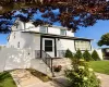 Charming Colonial-style home featuring a crisp white exterior with black trim accents and a covered front entrance Charming Colonial-style home featuring a crisp white exterior with black trim accents and a covered front entrance