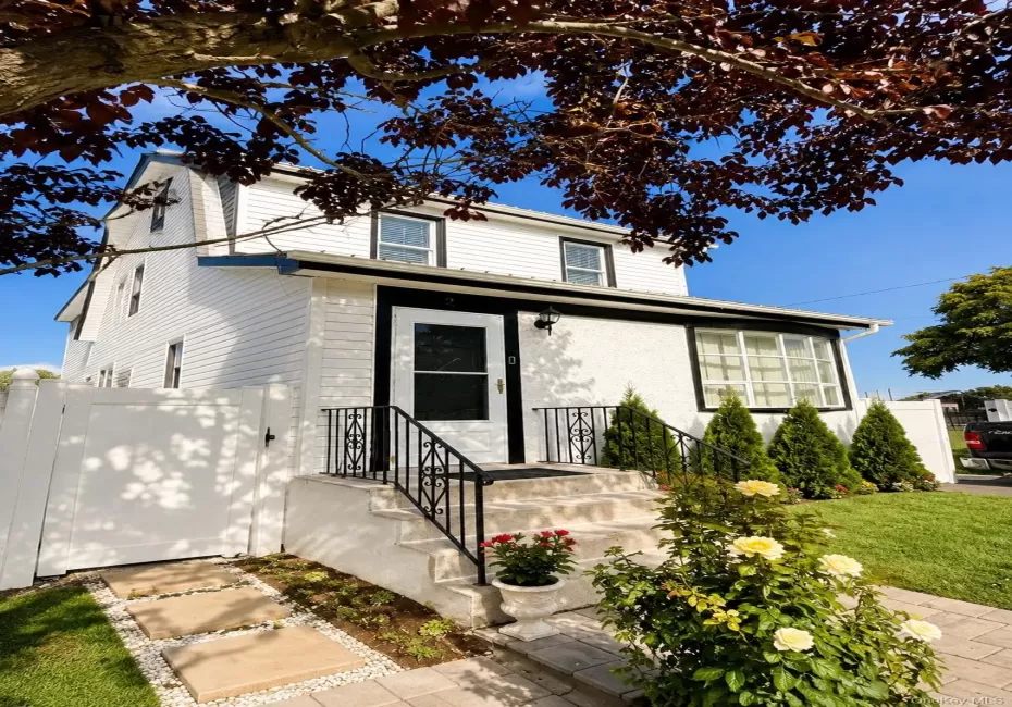 Charming Colonial-style home featuring a crisp white exterior with black trim accents and a covered front entrance Charming Colonial-style home featuring a crisp white exterior with black trim accents and a covered front entrance