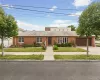 Brick exterior residence featuring a front lawn and paved walkway Brick exterior residence featuring a front lawn and paved walkway