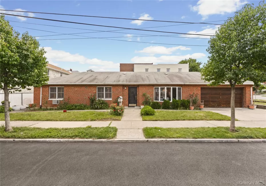 Brick exterior residence featuring a front lawn and paved walkway Brick exterior residence featuring a front lawn and paved walkway